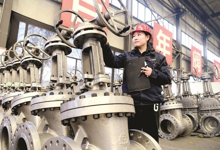 图为北京市阀门总厂股份生产车间内,企业员工正在检查产品